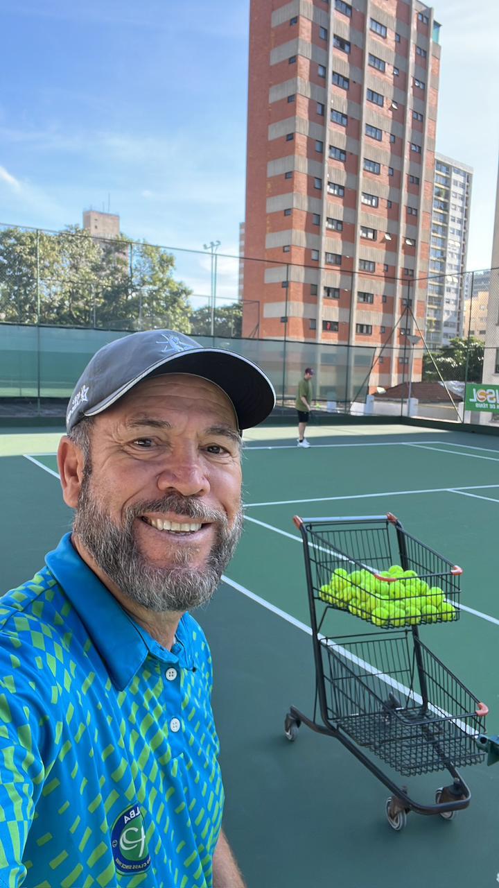 Professor em quadra com carrinho de bolas na Vip Tennis